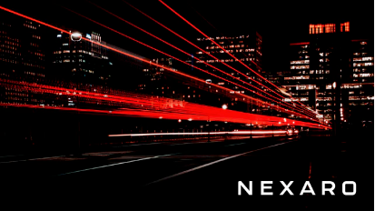 City street at night with red light trails and illuminated buildings; NEXARO text in bottom right corner.
