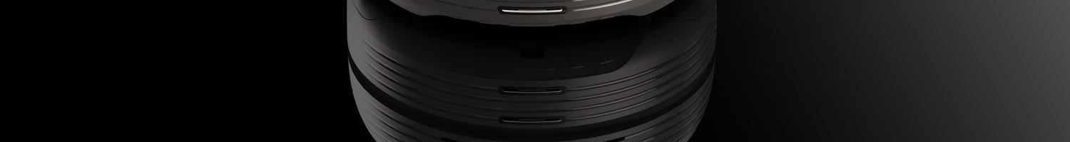 Close-up top view of a futuristic, black, cylindrical device with layered sections and metallic accents.