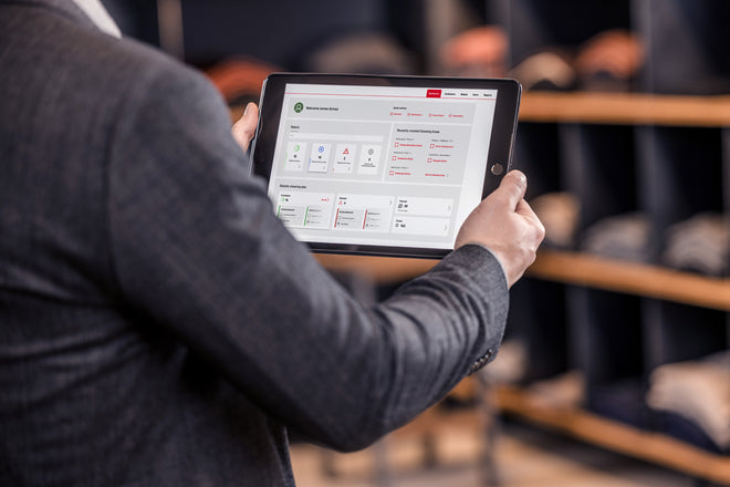 A sales assistant is holding a tablet with the Nexaro HUB open on it.