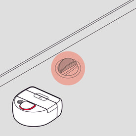 Robotic vacuum near a highlighted floor drain under a raised surface, illustrated in black, white, and red.