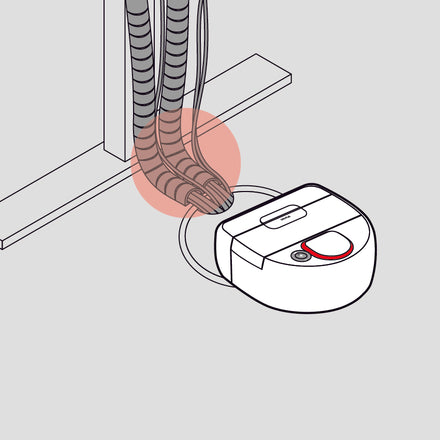 A robot vacuum is tangled in cords under a table, highlighted by a red circle.