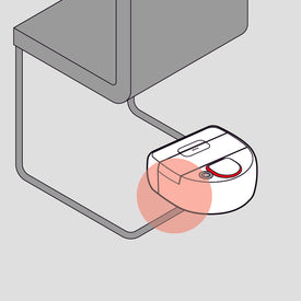 A robot vacuum stuck under a chair, highlighted with a red circle.