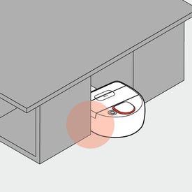 A robot vacuum is stuck under a cabinet, unable to move forward.