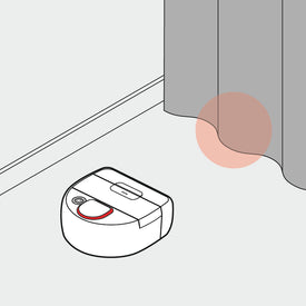 A robot vacuum cleaner approaches a curtain by a wall, highlighted with a red circle.
