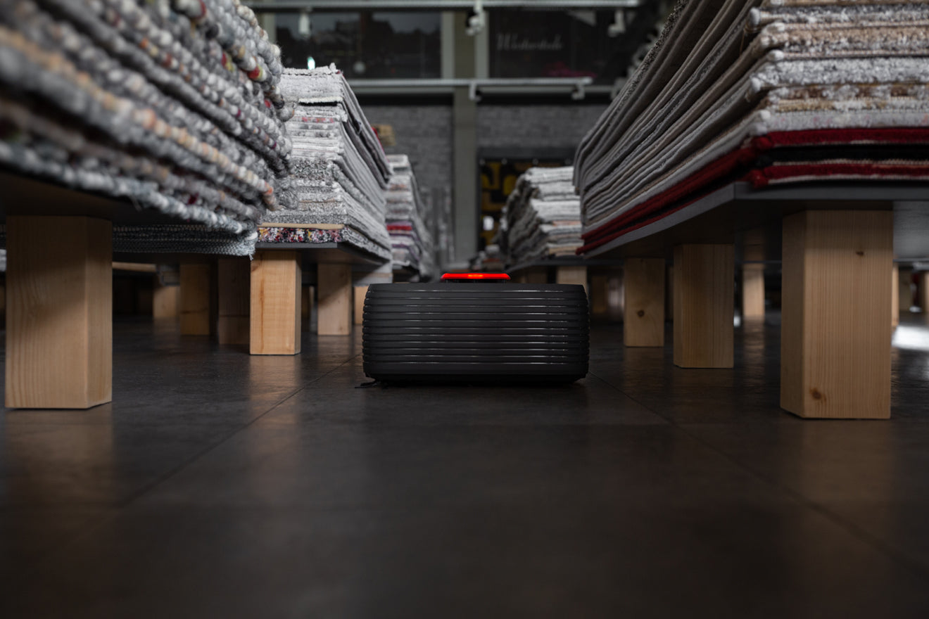 A Nexaro robot vacuum cleaner between pallets with carpets